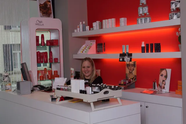 Onthaal van Buerna Lounge met de rode wand en verzorgingsproducten